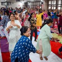 Delhi, India, June 19 2022 -Group Yoga Aerobics session for people of different age groups in Balaji Temple, Vivek Vihar, International Yoga Day, Big group of adults attending aerobics class in temple photo