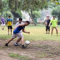 nueva delhi, india - 01 de julio de 2018 - futbolistas del equipo de fútbol local durante el partido en el campeonato regional de derby en un mal campo de fútbol. momento caliente del partido de fútbol en el campo verde de hierba del estadio foto