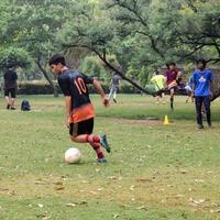 nueva delhi, india - 01 de julio de 2018 - futbolistas del equipo de fútbol local durante el partido en el campeonato regional de derby en un mal campo de fútbol. momento caliente del partido de fútbol en el campo verde de hierba del estadio foto