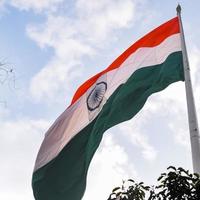 India flag flying high at Connaught Place with pride in blue sky, India flag fluttering, Indian Flag on Independence Day and Republic Day of India, tilt up shot, Waving Indian flag, Har Ghar Tiranga photo