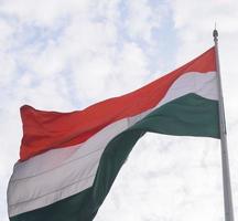 India flag flying high at Connaught Place with pride in blue sky, India flag fluttering, Indian Flag on Independence Day and Republic Day of India, tilt up shot, Waving Indian flag, Har Ghar Tiranga photo