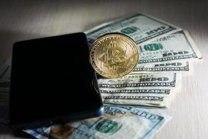 Concept with money american dollars bitcoin and mobile phone photo