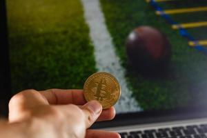 Golden bitcoin coin against digital currency sport, ball background photo