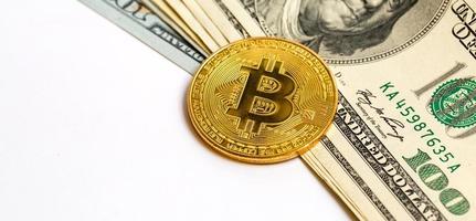 monedas simbólicas de bitcoin en billetes de cien dólares intercambian efectivo de bitcoin por un dólar foto