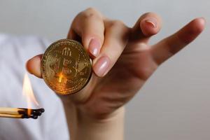 Bitcoin in hand on white background match, fire, flame, burning photo