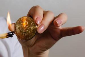 Bitcoin in hand on white background match, fire, flame, burning photo