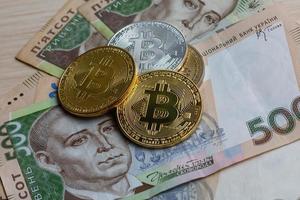 Bitcoin and ukraine national currency hryvnya on background photo