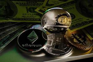 silver bitcoin on one hundred dollar bills photo