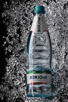 KRASNOYARSK, RUSSIA - OCTOBER 21, 2022 A bottle of Borjomi mineral water lies on crushed ice. photo