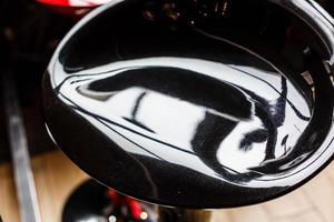 A black bar stool with a silver stand in front of the bar table photo