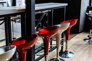 Left side of a row of red and pink square bar stools photo