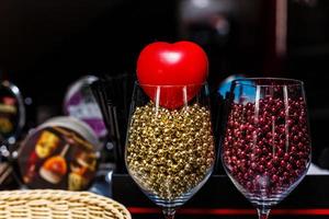 Two glasses and red heart with bokeh on background romantic photo