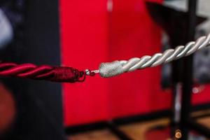 Closeup detail of a rope over a solid red background
