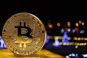 montones de monedas de bitcoin doradas y bolsa de regalo roja sobre fondo de guirnalda de navidad foto