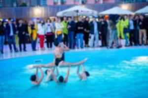 Blurred image of aqua fitness with group of senior people exercising in swimming outdoor pool photo