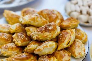 Close-up breakfast on a buffet fresh pastry patties with a filling on a white plate photo