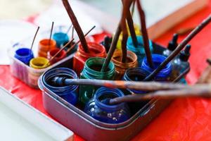 wooden art palette with paint and brushes, close up photo