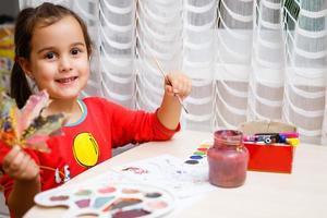 niña pintando sobre hojas amarillas de otoño con gouache artes infantiles creatividad infantil arte otoñal foto