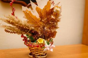 Basket with scattered autumn maple leaves on a white background photo