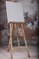 White empty artistic canvas on an easel for drawing images by an artist on a gray background photo