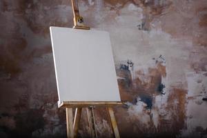 White empty artistic canvas on an easel for drawing images by an artist on a gray background photo