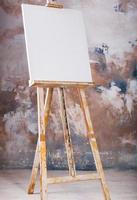 White empty artistic canvas on an easel for drawing images by an artist on a gray background photo