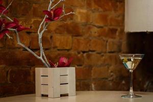 a glass with martini and olive spring decor photo