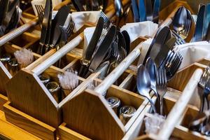 The forks and knives in a wooden stand photo