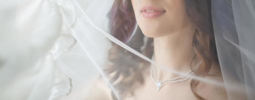 Close up portrait of a pretty shy bride with a veil photo