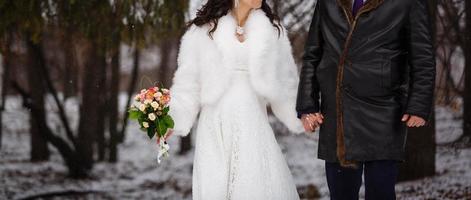 The bride and groom walk with the deer unusual winter wedding photo