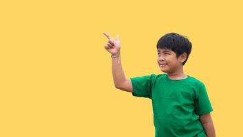 The boy smiled and pointed his hand to his side. on a yellow background photo