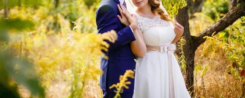 retrato de sol de la novia y el novio felices al aire libre en un lugar natural al atardecer cálido verano foto