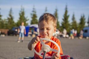 A boy driving a children's car. Joyful emotions. Children, portrait. photo