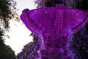 el cuenco de la fuente en la suave luz del atardecer. hermosa iridiscencia de las gotas de agua de la fuente. foto