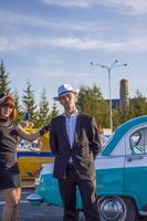 2022-08-12 tatarstán, distrito de verkhneuslonsky, pueblo de savino. ciudad turística colinas sviyazhsky. festival de autos históricos de kazán. un hombre y una mujer con ropa retro posan cerca de los autos. foto