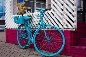 The decoration of vintage bicycle and white building . Old blue retro bike and holiday house background. photo