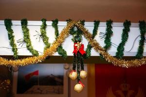 Christmas angel rag doll hanging . Amid a festive candle holder with candles. Celebration of New year and Christmas at home photo