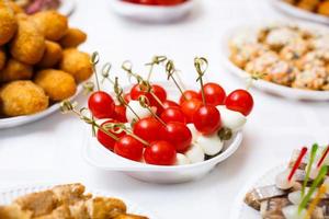 bistec a la parrilla, verduras a la parrilla, papas, ensalada, diferentes bocadillos y limonada casera en una mesa rústica de madera, vista superior foto