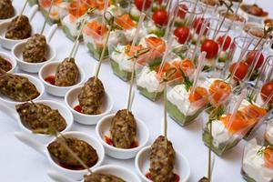 Little glasses with fresh salads stand on white table photo