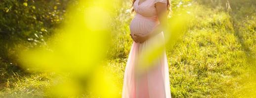 Close up of pregnant belly in nature photo