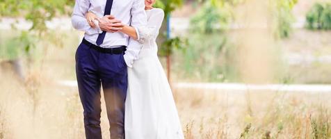 Newlyweds groom and bride walking in autumn park photo