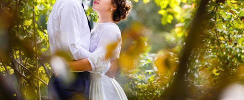 Newlyweds groom and bride walking in autumn park photo