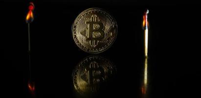 Golden bitcoin on black background with copy space cryptocurrency mining concept burns photo