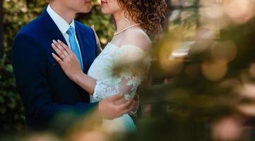 novia y novio en el día de la boda caminando al aire libre en primavera naturaleza pareja nupcial feliz recién casado foto