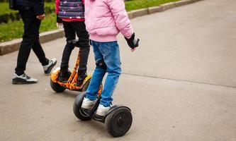 Young woman riding hoverboard electrical scooter personal eco transport new modern photo