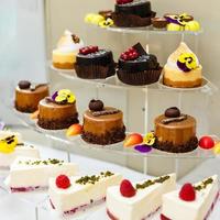 Cupcake with whipped cream and cake on the stands in a showcase photo