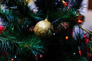 rama de abeto con bolas y luces festivas en el fondo de navidad con destellos. foto