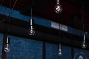 Retro light bulbs hang in interior with white brick wall background. light bulbs hanging on brick wall backdrop