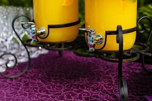 Bank of lemonade with citrus fruits on a buffet table photo