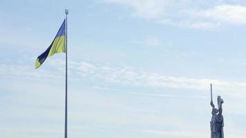 de ukrainska flagga fladdrande i de vind mot de blå himmel, nära de känd staty av de fosterland. känd sevärdheter, monument och monument av Kiev. Ukraina, kyiv - oktober 08, 2022. video